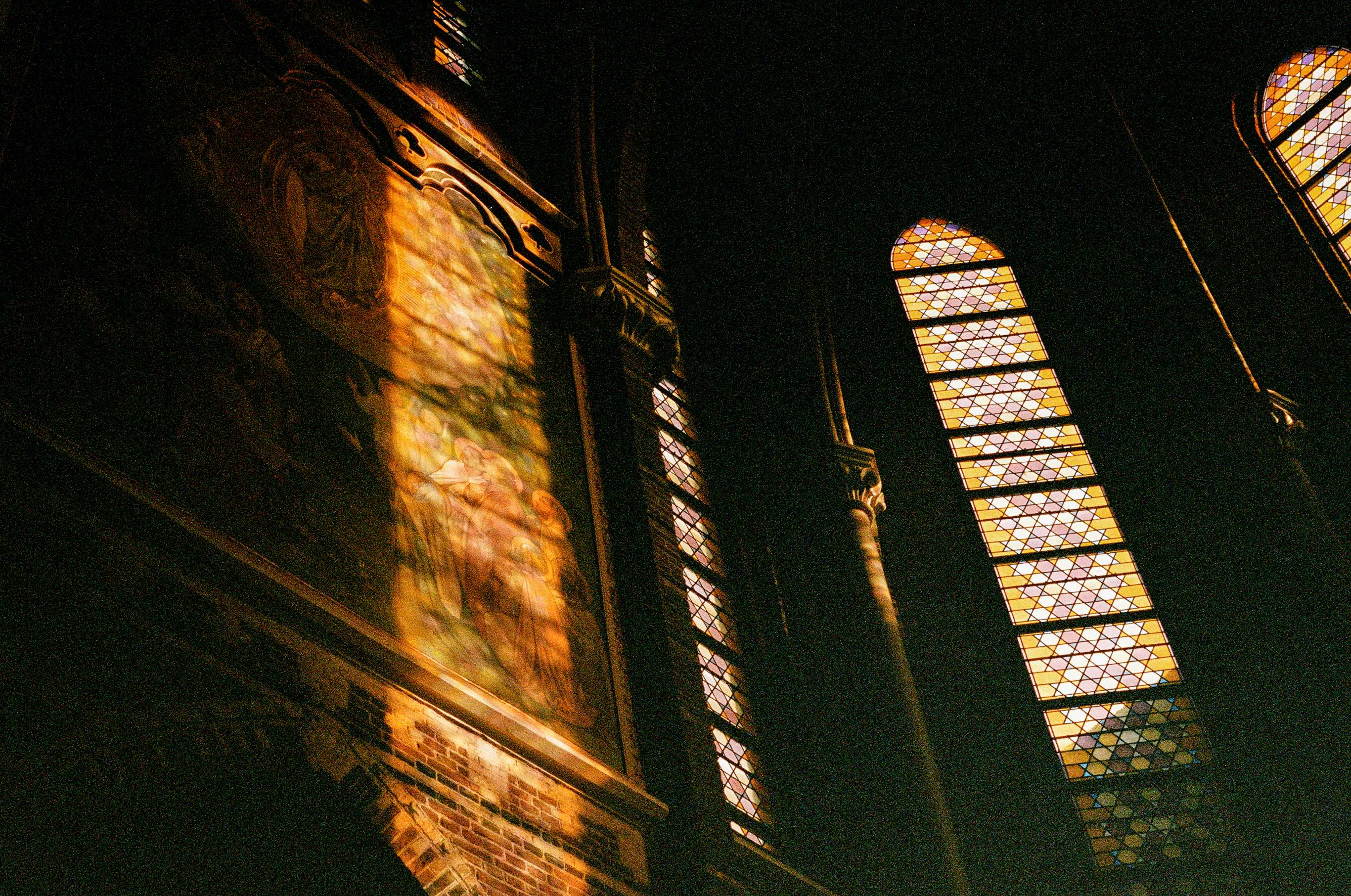 Interior of cathedral with stained glass windows and light streaming through