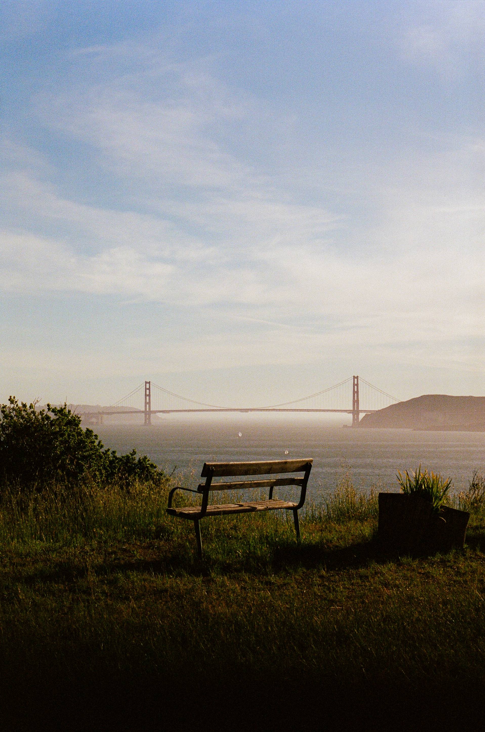 Wooden bench overlooking Golden Gate Bridge with fog in the distance